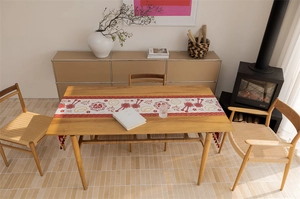Close-up of Chinese New Year table runner featuring red tassels and woven jacquard floral patterns