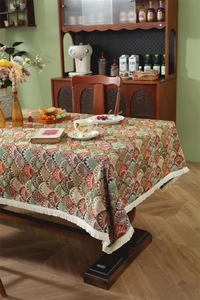 Detail of vintage geometric jacquard tablecloth featuring white tassels on dark wood