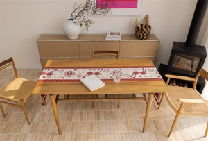 Detailed texture of red jacquard table runner with golden patterns and elegant tassels