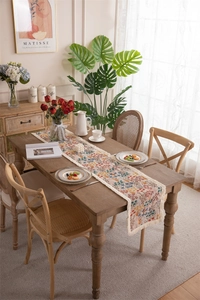 Detailed view of floral table runner with beige tassels and colorful jacquard pattern