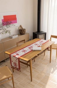 Close-up of Chinese festive table runner with red tassels and traditional jacquard patterns