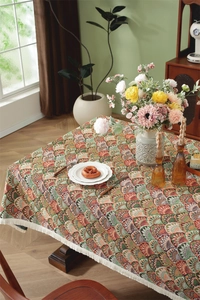 Close-up of retro floral jacquard tablecloth with bohemian patterns and white fringe tassels