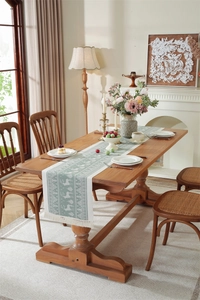 Detail of light green jacquard table runner with woven reindeer and spruce forest pattern