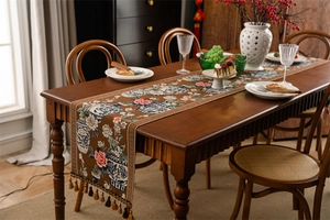 Détail d'un chemin de table de style chinois avec motifs floraux jacquard et glands