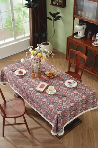 Detailed close-up of vintage floral jacquard tablecloth with fan pattern and white fringe