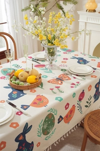Detail of Easter tablecloth showing tassel edges and colorful bunny floral patterns