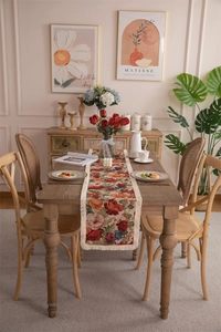 Close-up of vintage floral jacquard table runner with delicate cream fringe tassels