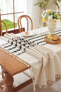 Detail of bohemian table runner with black geometric embroidery and fine fringe edges