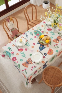 Detailed close-up of Easter tablecloth with white tassels and floral bunny prints