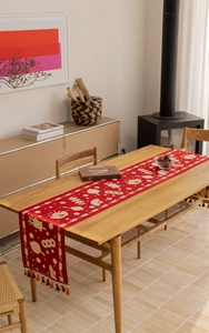 Macro detail of red festive jacquard table runner with Fu characters and elegant tassels
