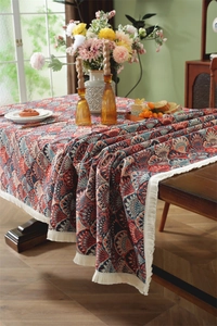 Close-up of vintage floral jacquard tablecloth with delicate fringe and bohemian pattern