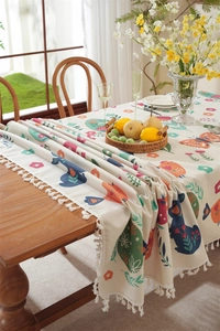 Detail of Easter tablecloth showing colorful rabbit prints and white tassel edges