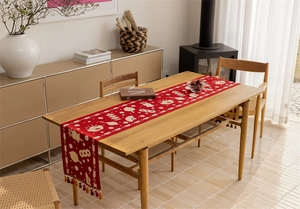 Macro detail of red festive table runner with traditional Chinese patterns and tassels