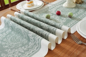 Close-up of jacquard table runner with bean green floral pattern and woven fabric texture