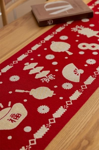 Macro detail of red festive table runner with traditional Chinese jacquard and tassels