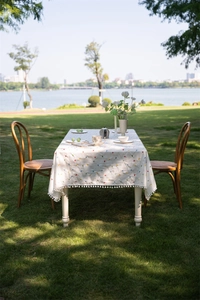 Detail of French cotton tablecloth with geometric patterns and pom-pom fringe edges