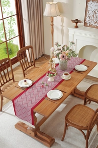 Detail of red and white geometric diamond jacquard table runner with delicate white tassels