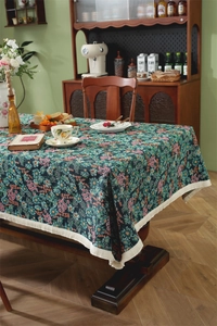 Detail of vintage floral tablecloth with white fringe trim and jacquard texture