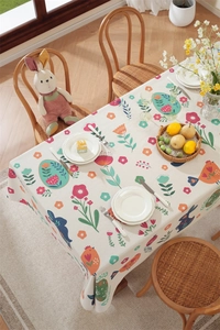 Close-up of Easter tablecloth featuring printed rabbits, colorful eggs and floral patterns