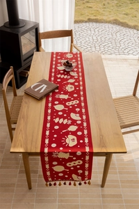 Detailed red festive table runner with golden jacquard patterns and elegant tassels