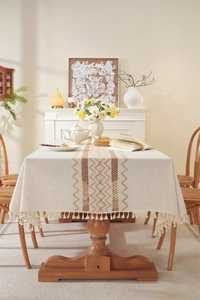 Detail of linen table runner featuring woven geometric patterns and decorative tassels