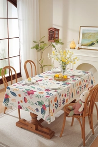 Detailed view of floral Easter tablecloth with bunny prints and elegant tassel edges