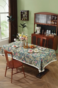 Close-up of vintage floral jacquard tablecloth with elegant beige fringe tassel borders