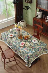 Macro shot of floral jacquard tablecloth with elegant white fringe tassel detail