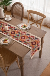 Close-up of geometric jacquard patterns and white tassels on a vintage table runner