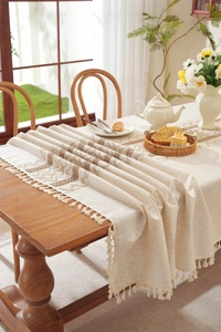 Macro detail of bohemian linen table runner with tassel fringe and wavy jacquard pattern