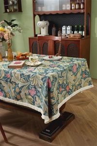 Detail of vintage jacquard tablecloth with floral patterns and creamy white tassels