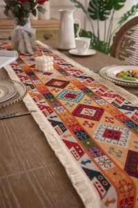 Close-up of bohemian table runner featuring ethnic jacquard weave and cream tassels