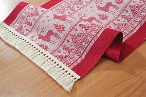 Detail of Christmas table runner featuring jacquard reindeer patterns and cream tassels