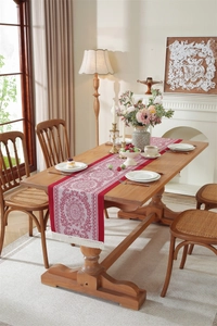 Detail of burgundy jacquard table runner with mandala patterns and cream tassels