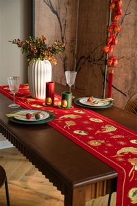 Detail of red festive Chinese table runner with golden koi and lantern embroidery