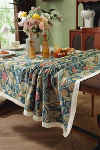Close-up of retro floral jacquard tablecloth with intricate patterns and fringe edges
