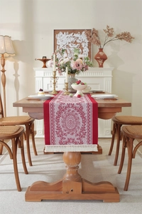 Close-up of vintage red and white floral jacquard table runner with decorative fringe