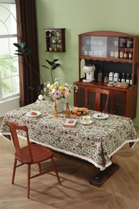 Close-up of vintage floral jacquard pattern and white tassel fringe on tablecloth