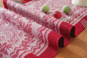 Close-up of jacquard Christmas table runner with reindeer and tree patterns on wood table