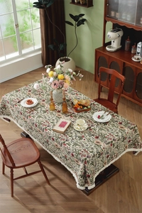 Close-up of vintage floral jacquard tablecloth with elegant white fringe tassel edges