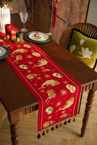 Detail view of red Chinese table runner with gold koi embroidery and colorful tassels