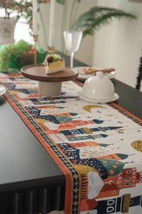 Close-up of jacquard table runner with moon and castle patterns on a wooden surface