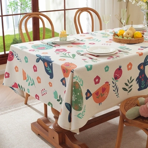 Rectangular Easter tablecloth with rabbit floral prints and tassels on a wooden table