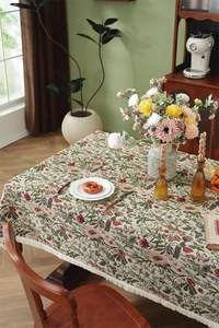 Close-up of vintage floral tablecloth featuring thick fabric and beige fringe edges
