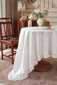 Detailed embroidery and ruffle edge on white vintage cotton tablecloth for round tables