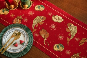 Detail of red festive table runner with traditional koi and lantern jacquard patterns