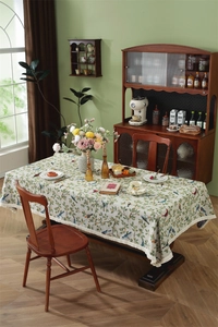 Detail of vintage bird and plant jacquard tablecloth with decorative fringe borders
