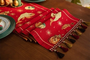 Detailed view of red festive table runner with jacquard koi fish and tassel edges