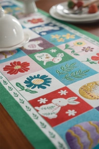 Detailed view of woven Easter table runner featuring bunnies, eggs and floral patterns