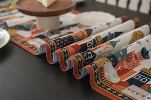 Detail of woven table runner featuring exotic tower patterns and textured fabric finish